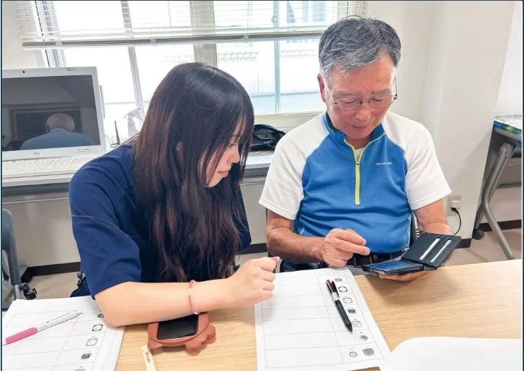 地域の方にスマートフォンの使い方を教える生徒